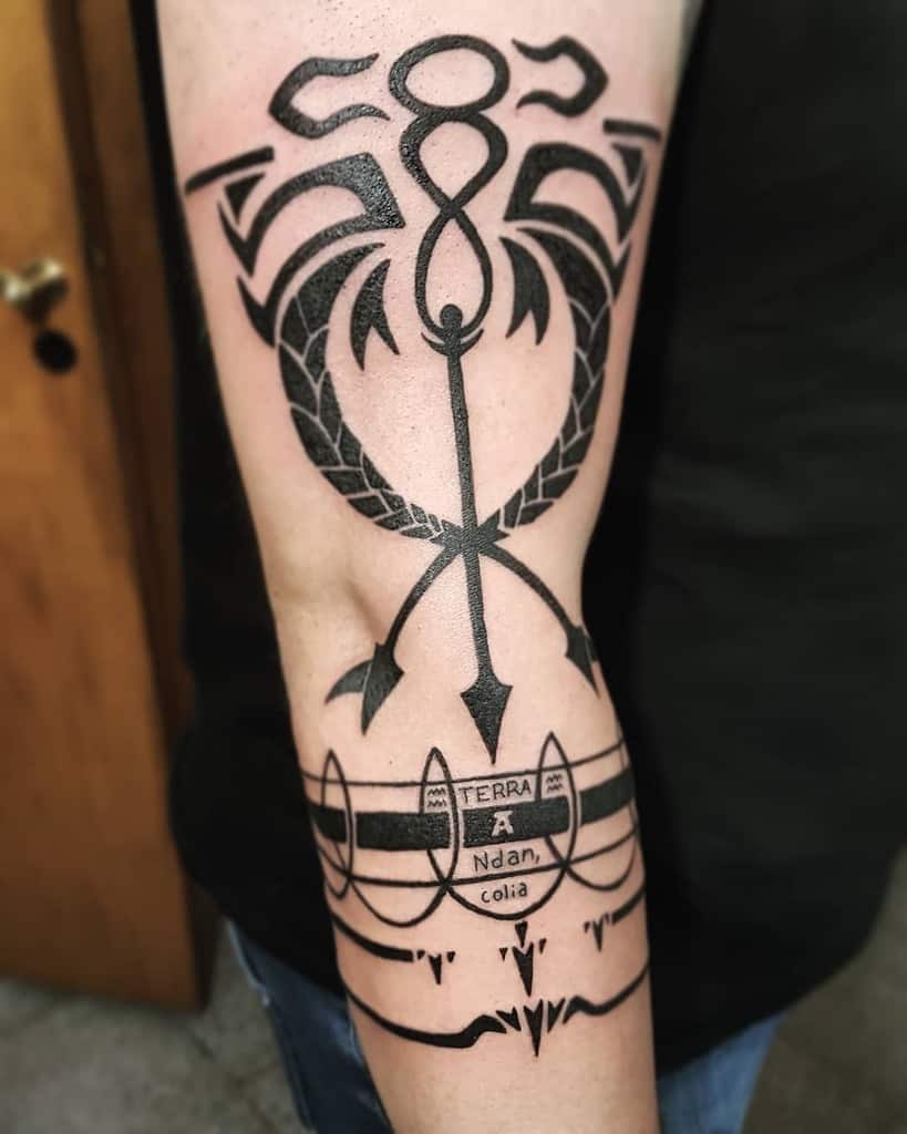 Fullmetal Alchemist tattoo of Scar’s Ishvalan alchemy markings, featuring bold black geometric designs and symbolic text