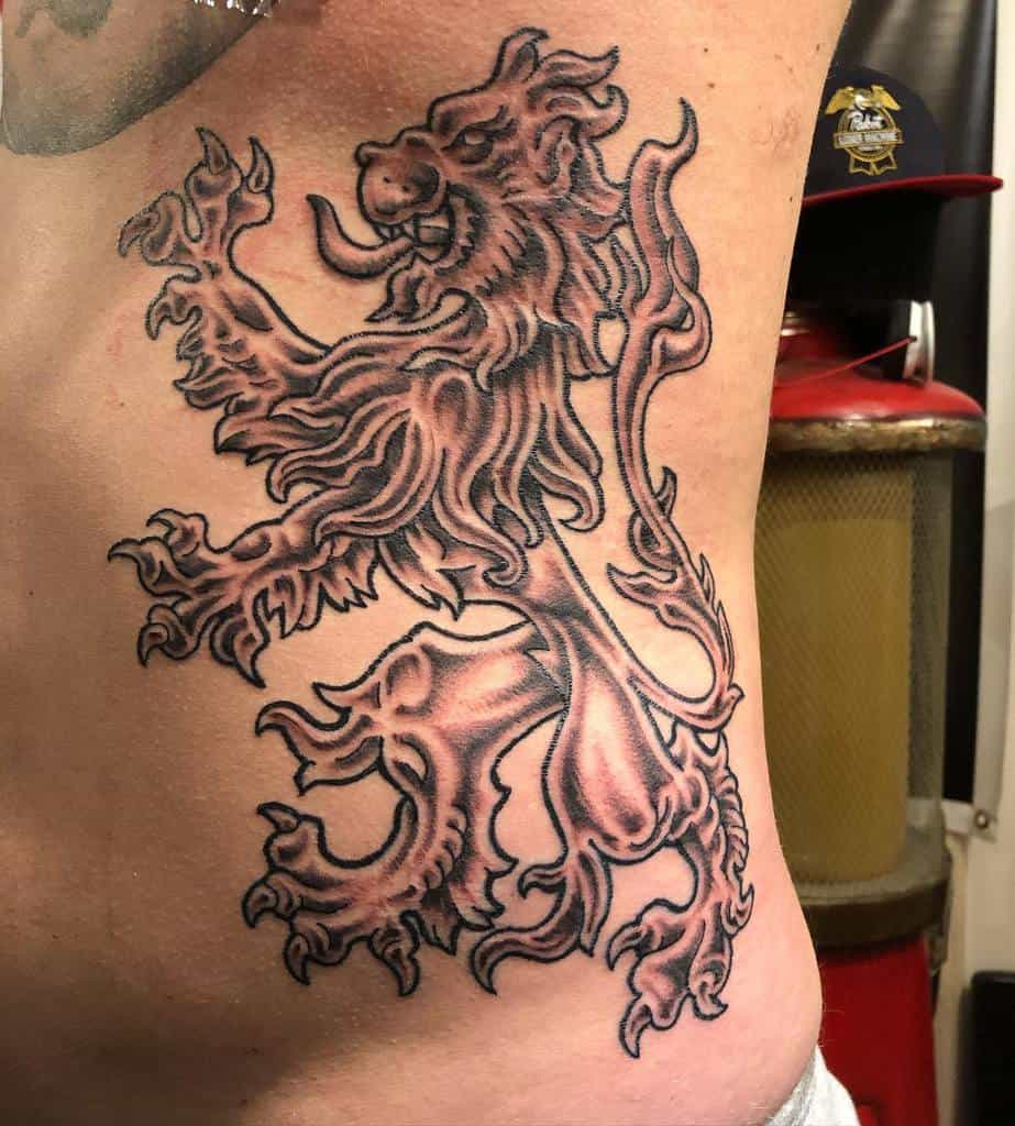 Tattoo of a fierce, stylized Scottish lion in a rampant position with intricate detailing outlining its features