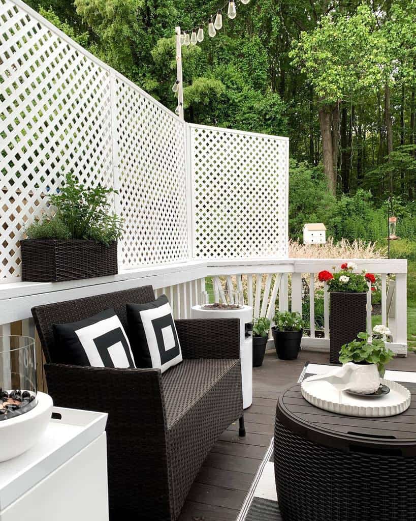 wood deck white fence and railing brown wicker sofa and table