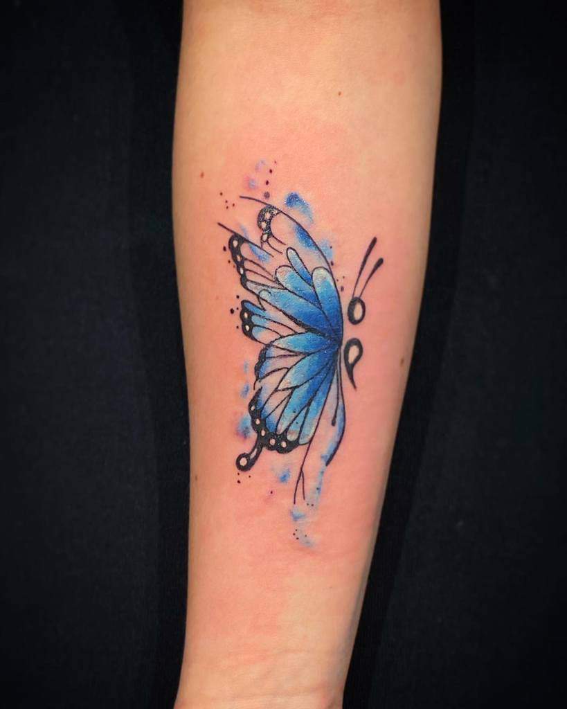 A beautiful blue semicolon butterfly tattoo on the forearm with delicate watercolor effects and dot accents, symbolizing hope, transformation, and mental health awareness