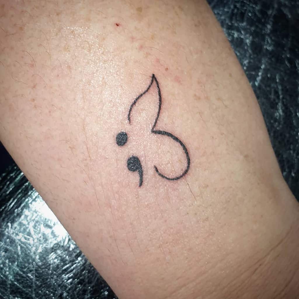 A simple semicolon butterfly tattoo with soft, minimal lines, representing resilience, hope, and a reminder of strength through mental health challenges