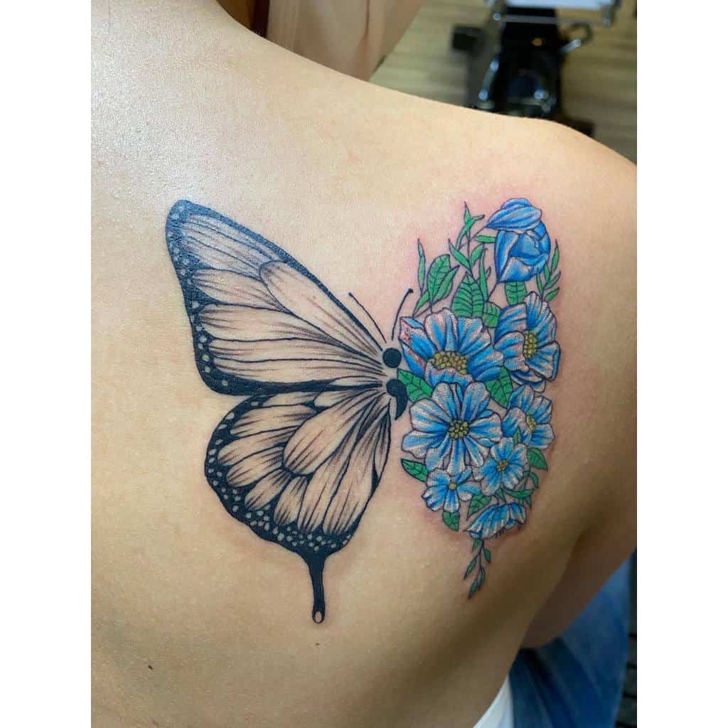 A back tattoo with a butterfly wing on the left and blue flowers on the right. and semicolon inbetween