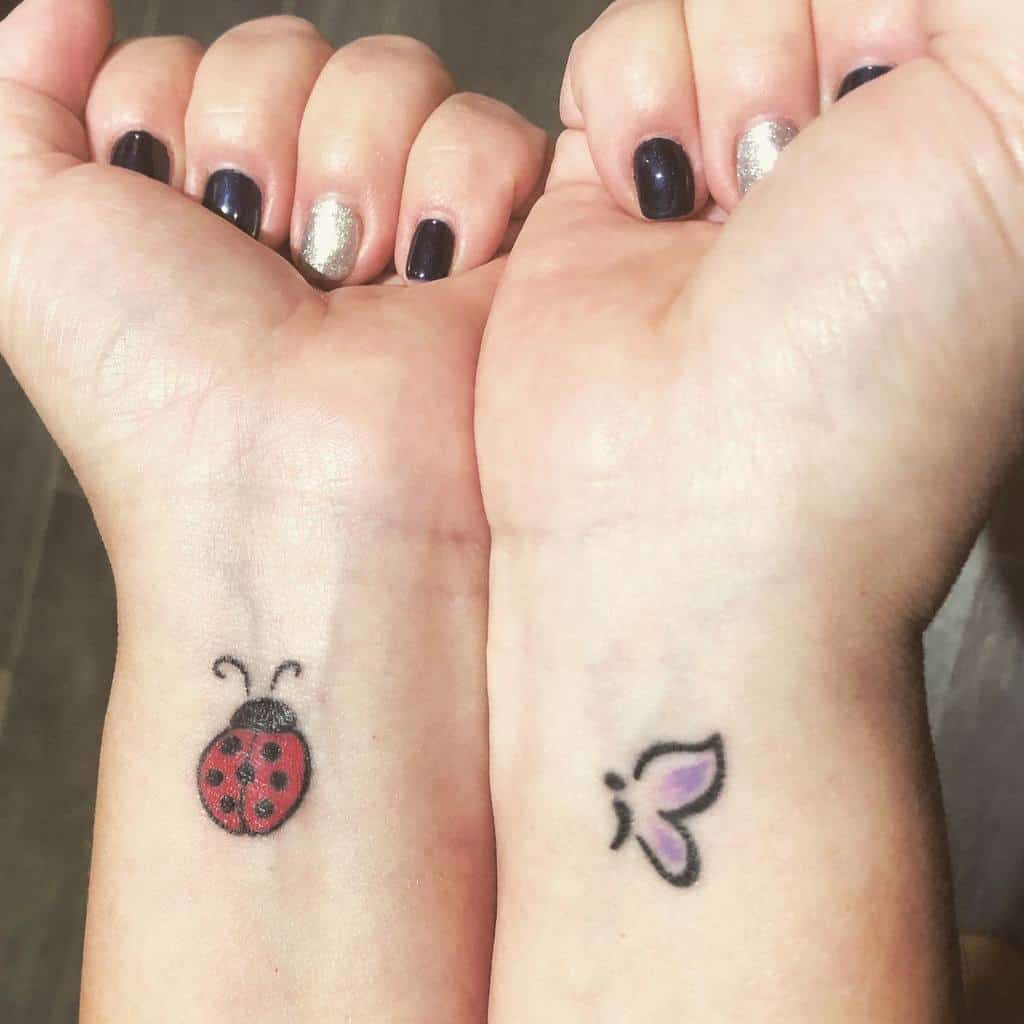 Close-up of two wrists with tattoos: a ladybug on one wrist and a butterfly on the other wrist