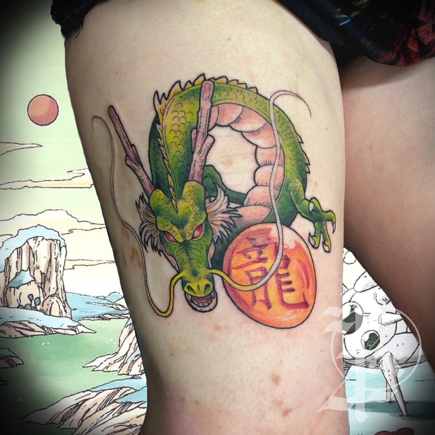 A vibrant Shenron tattoo on the thigh, holding a Dragon Ball with a mystical backdrop