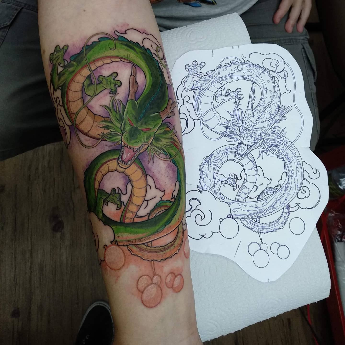 A colorful Shenron dragon tattoo on a forearm