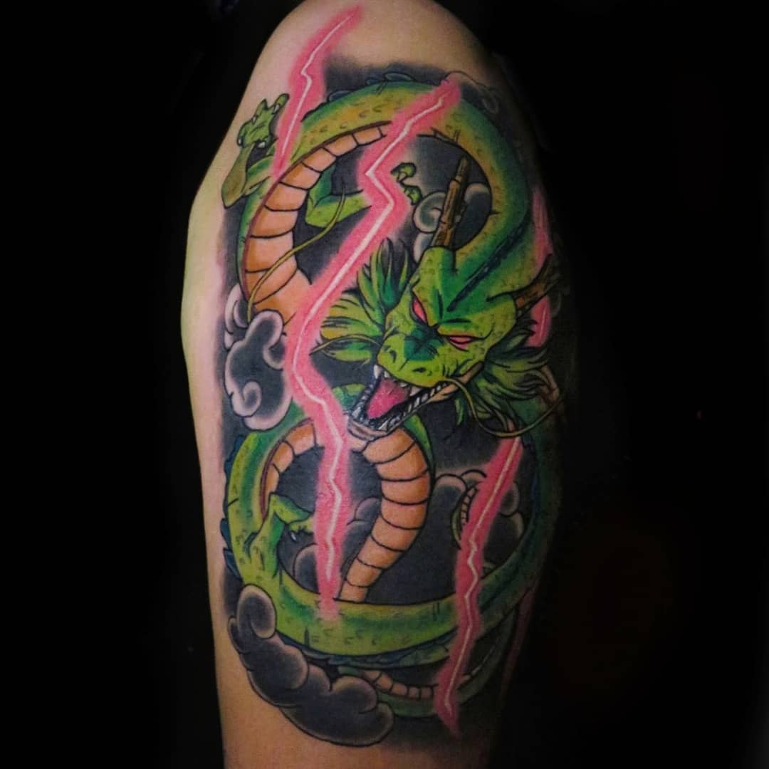 Dynamic tattoo of Shenron on the shoulder, surrounded by bold pink lightning and dark clouds