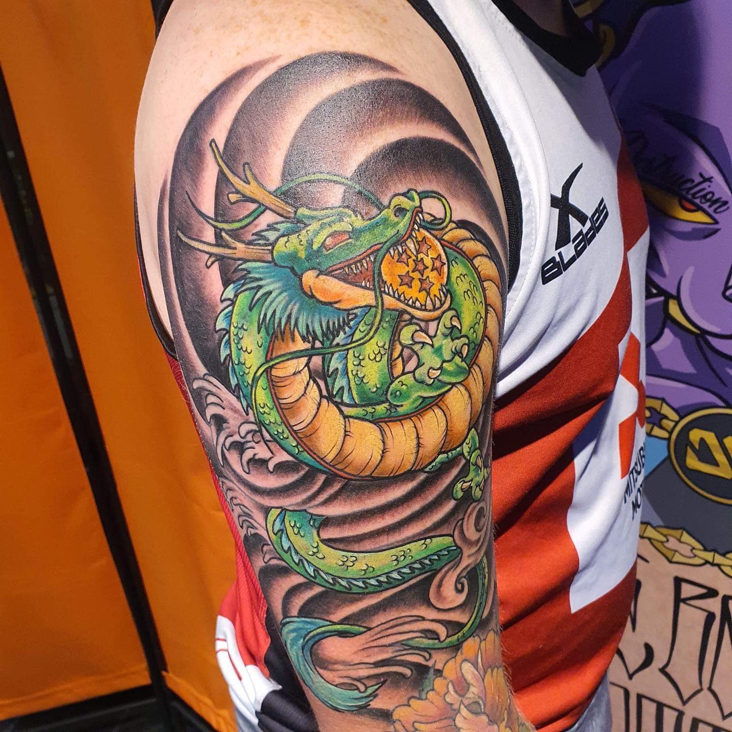 A dynamic tattoo of Shenron wrapping around the upper arm, featuring bold colors and a swirling background