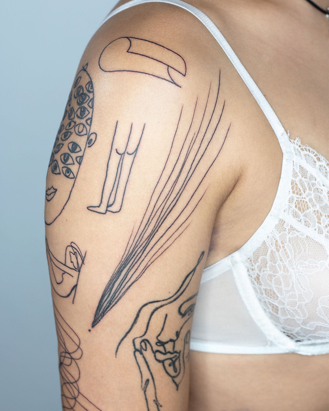 Arm with various abstract line tattoos