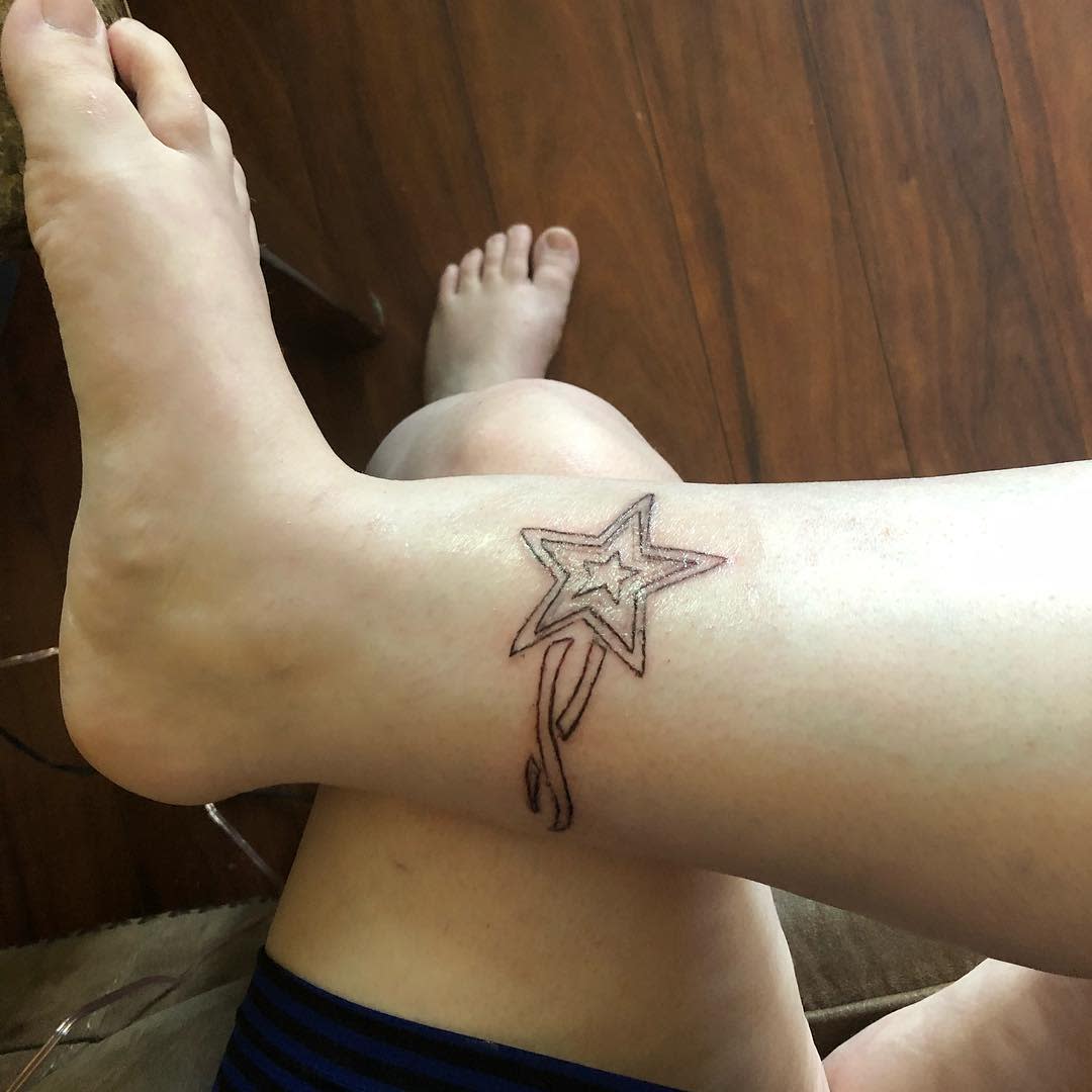 Outline of a star tattoo on the inner ankle