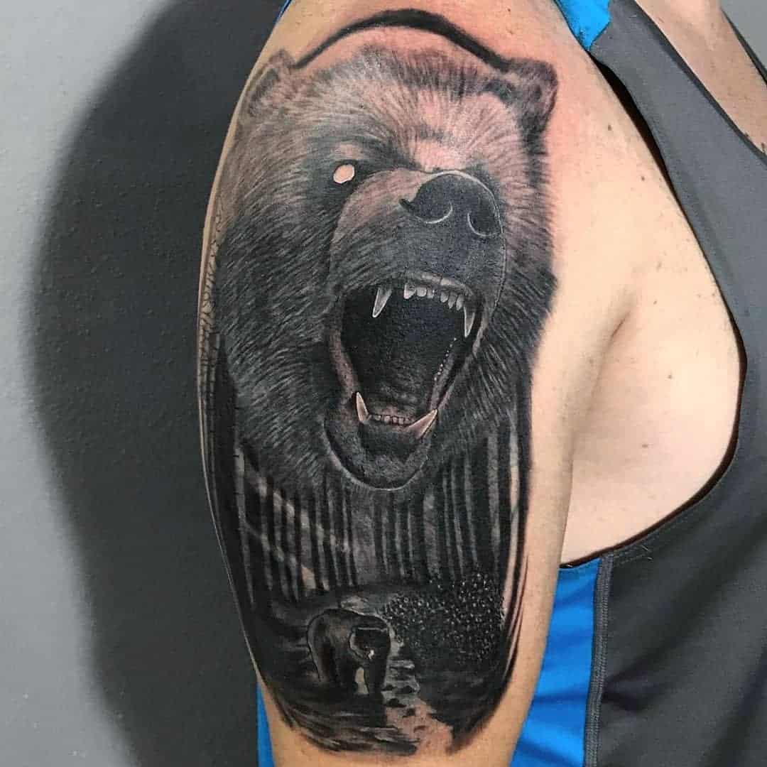 Roaring bear tattoo with wilderness scene on upper arm
