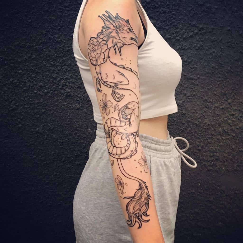 Arm tattoo of a dragon and flowers on a woman