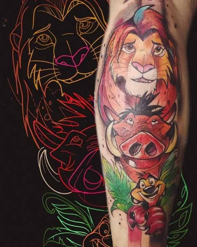 Bold and colorful tattoo of Simba, Timon, and Pumbaa, surrounded by lush green leaves