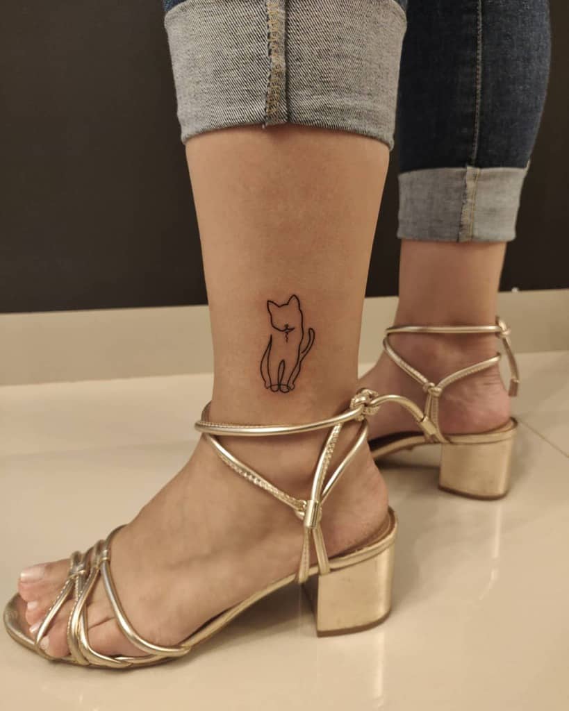Minimalist cat outline tattoo on ankle