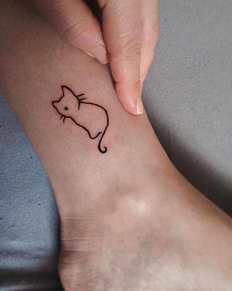 Outline tattoo of a cat on an ankle