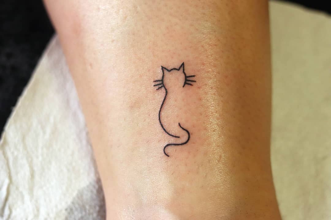 Simple cat outline tattoo on a person's skin