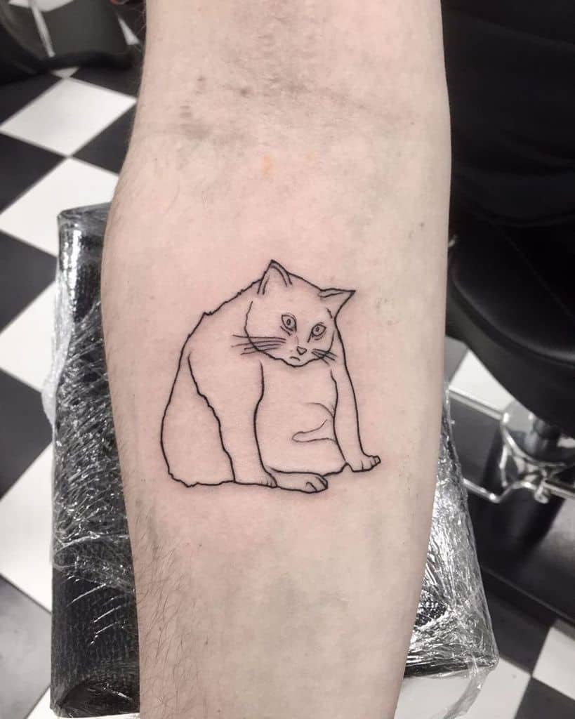 Outline tattoo of a sitting cat on a person's arm