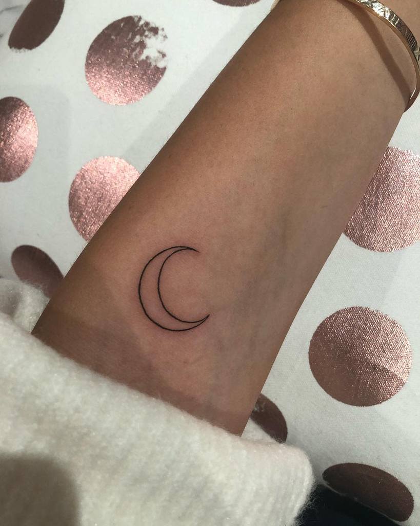 Simple outline tattoo of a crescent moon