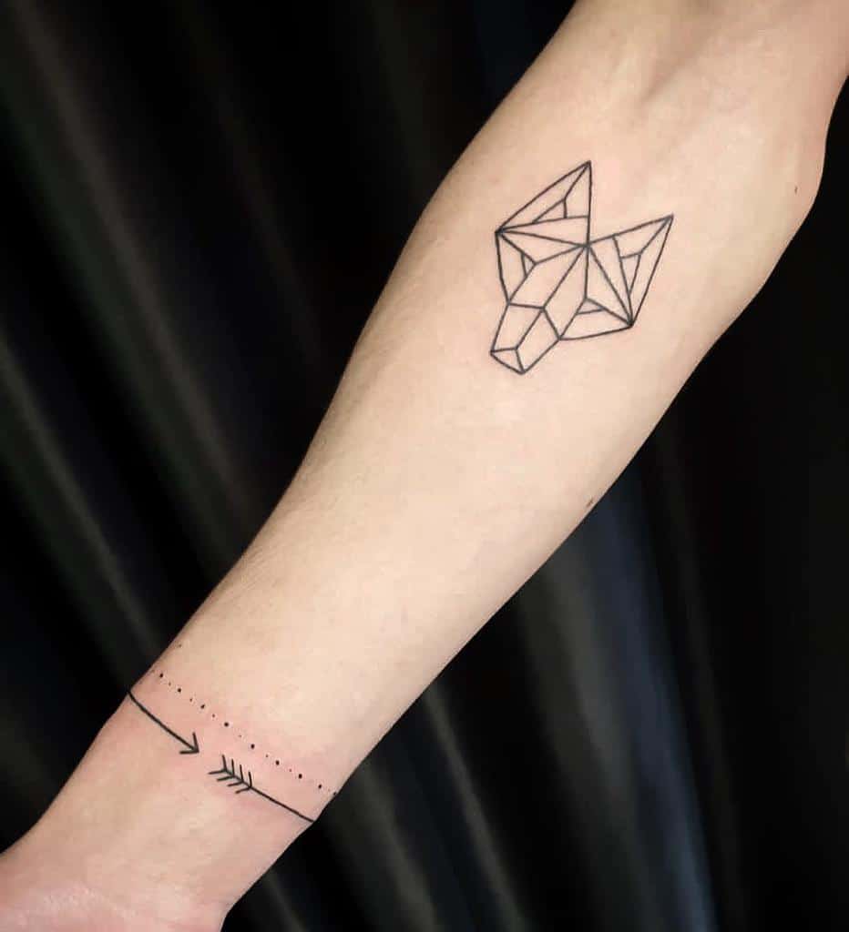 Geometric fox tattoo above an intricate arrow bracelet on the forearm