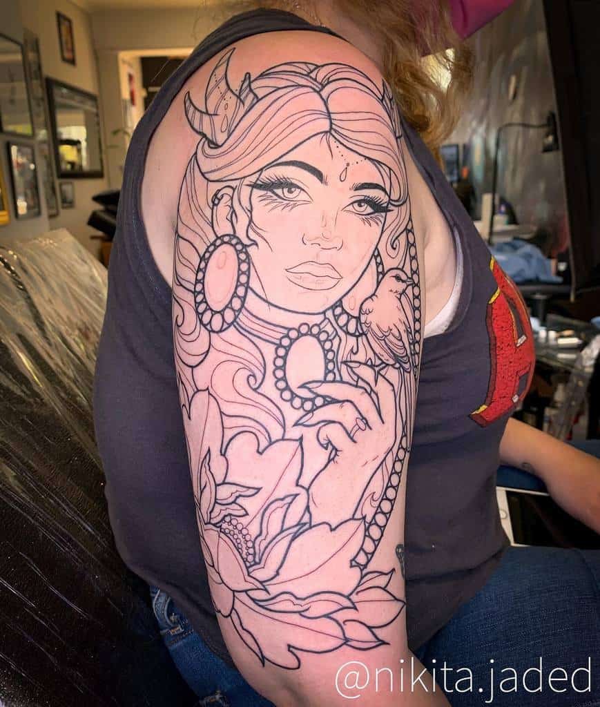 Line tattoo of a woman's face with jewelry and flowers on a woman's upper arm
