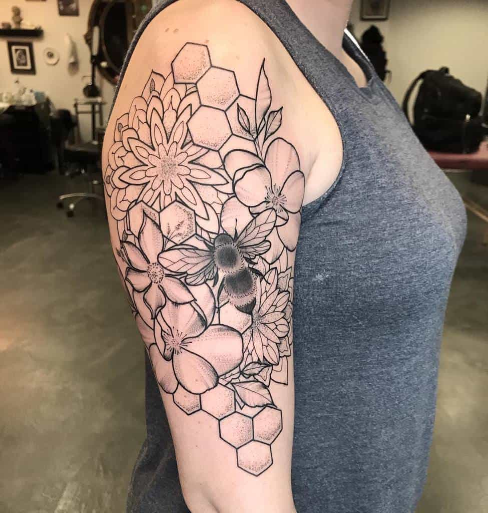 Arm tattoo with floral and geometric patterns in black ink