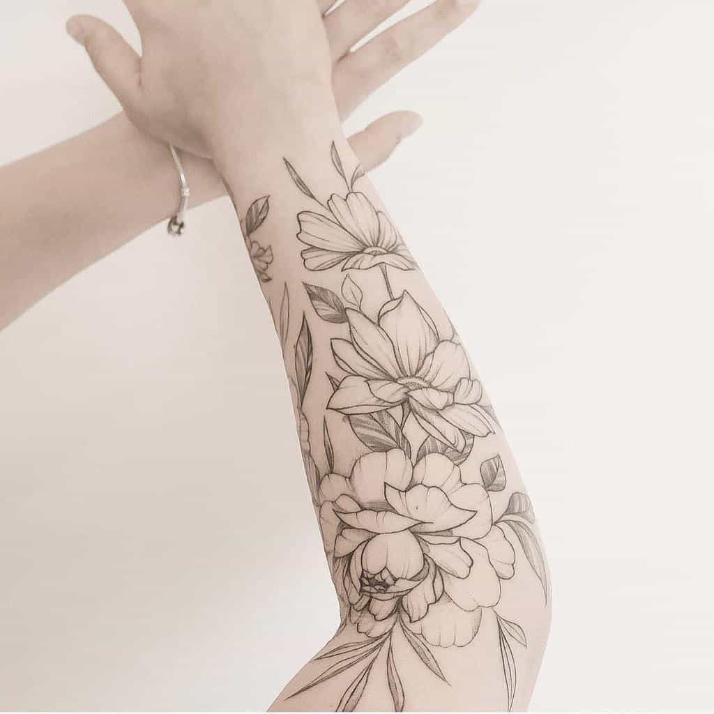 Half sleeve tattoo with large flowers and leaves on a forearm