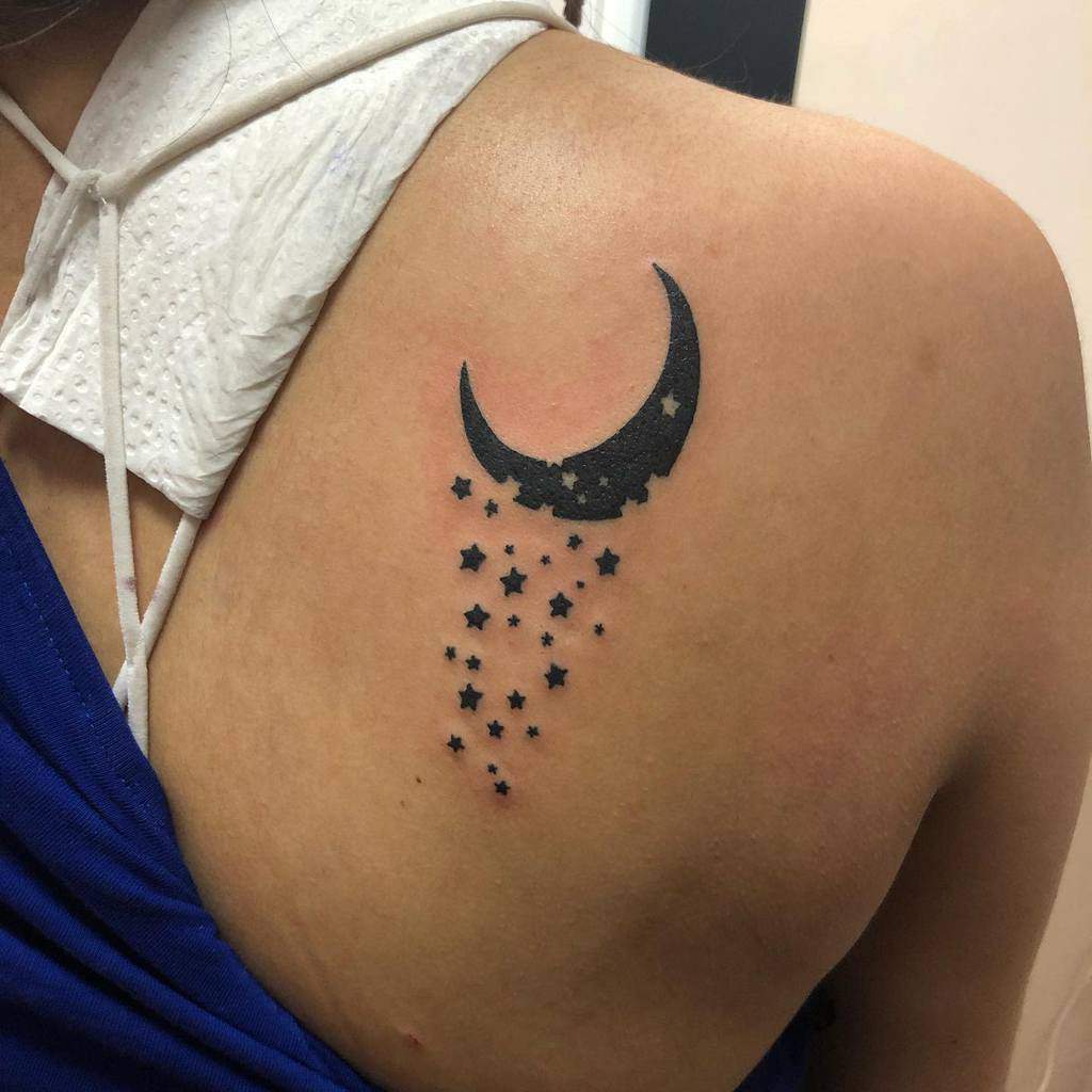 Crescent moon tattoo with small stars on upper back