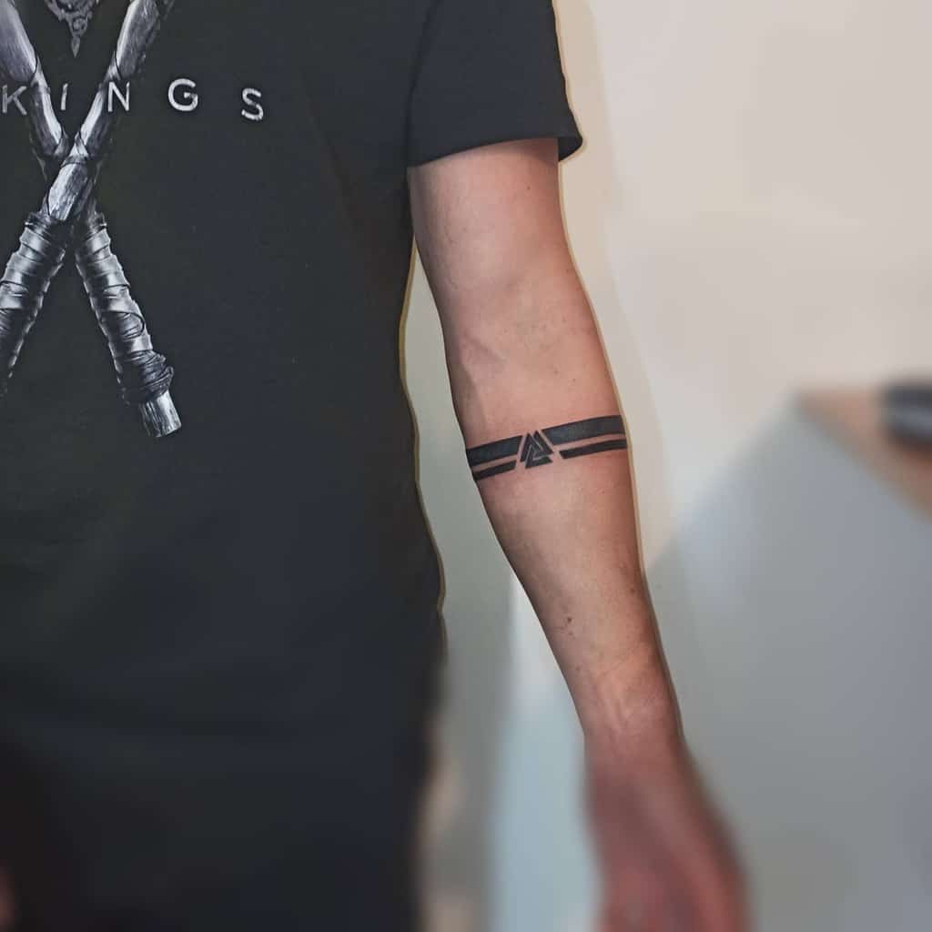 Black armband tattoo featuring a triangle design on the forearm