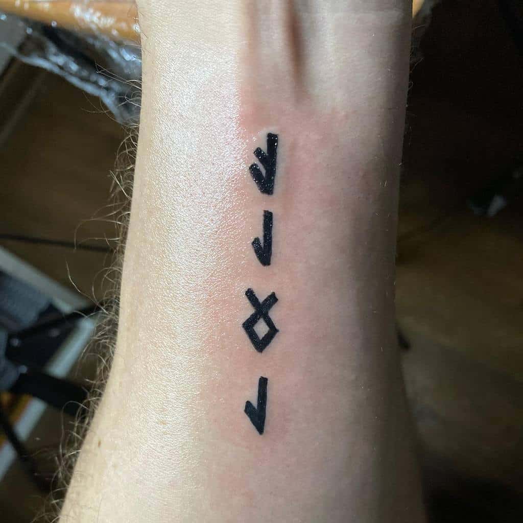 Minimalistic Nordic rune tattoo on the forearm, featuring a vertical sequence of runes, symbolizing personal meaning or protection