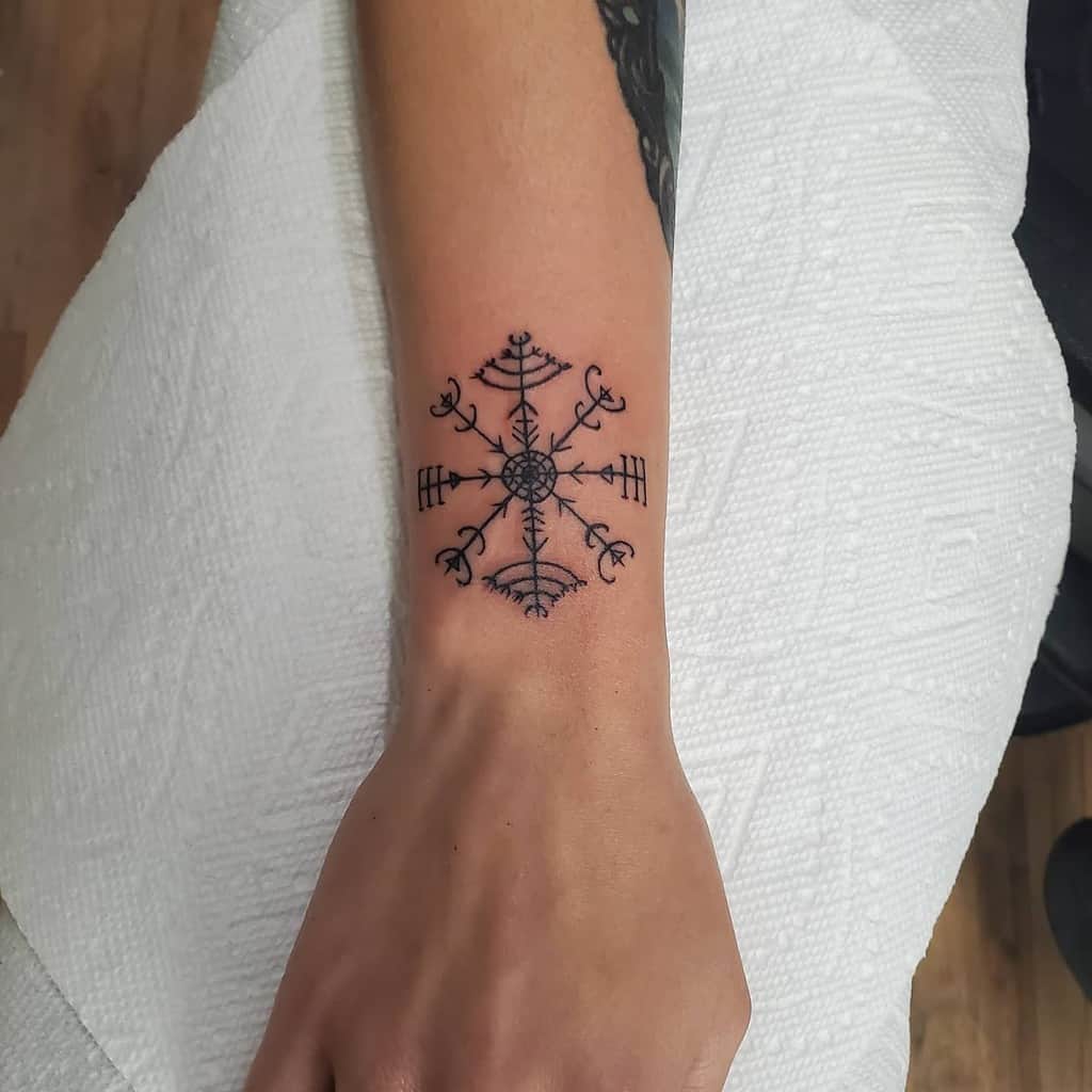 A Nordic compass tattoo on a forearm