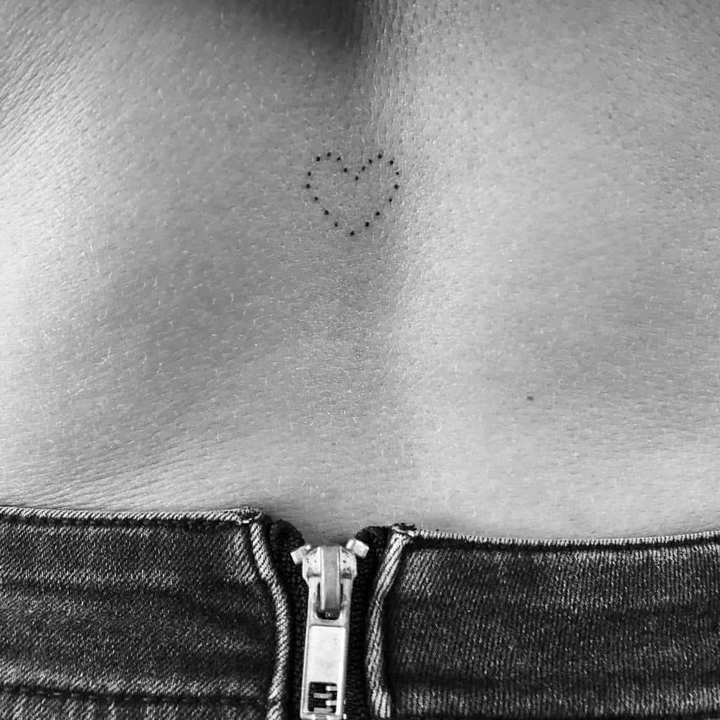 Tiny dotted black heart tattoo, offering a subtle and intimate symbol of love
