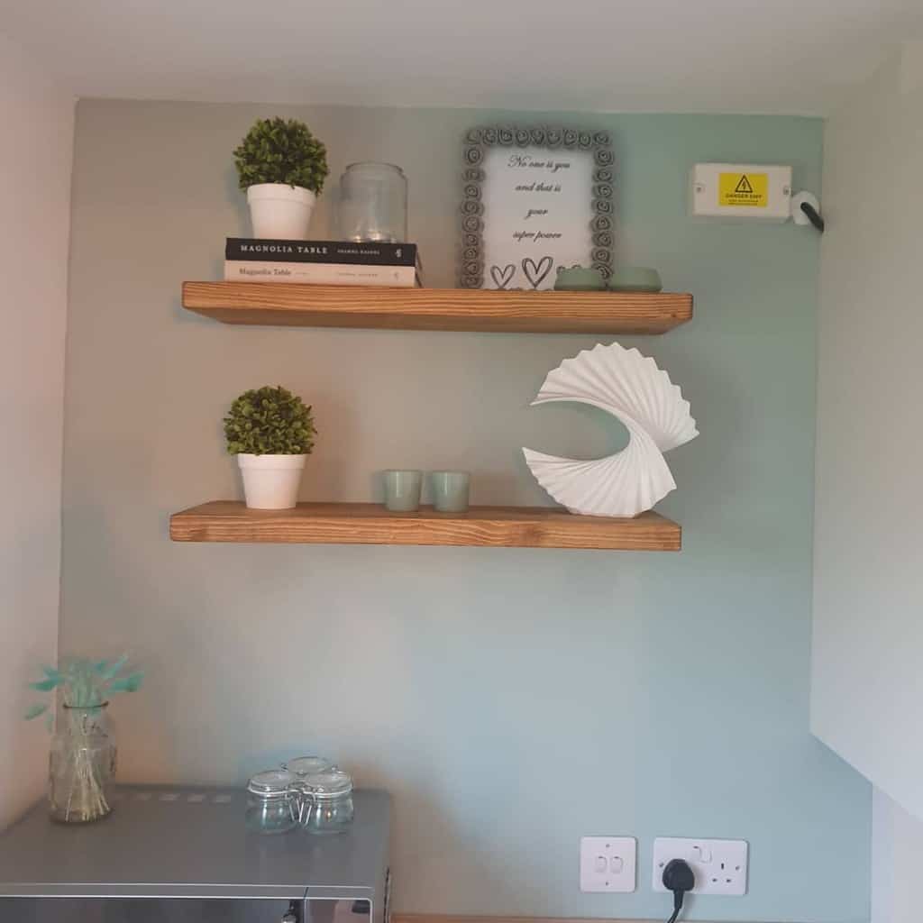 blue accent wall with wood mounted shelves in kitchen