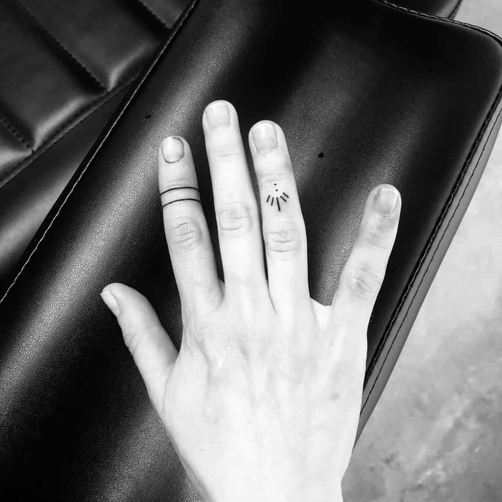 Hand with minimalist tattoos on fingers