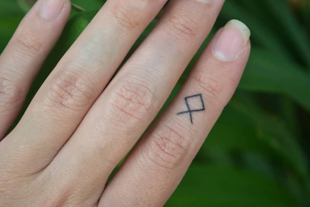 Hnd with a small geometric tattoo on the finger