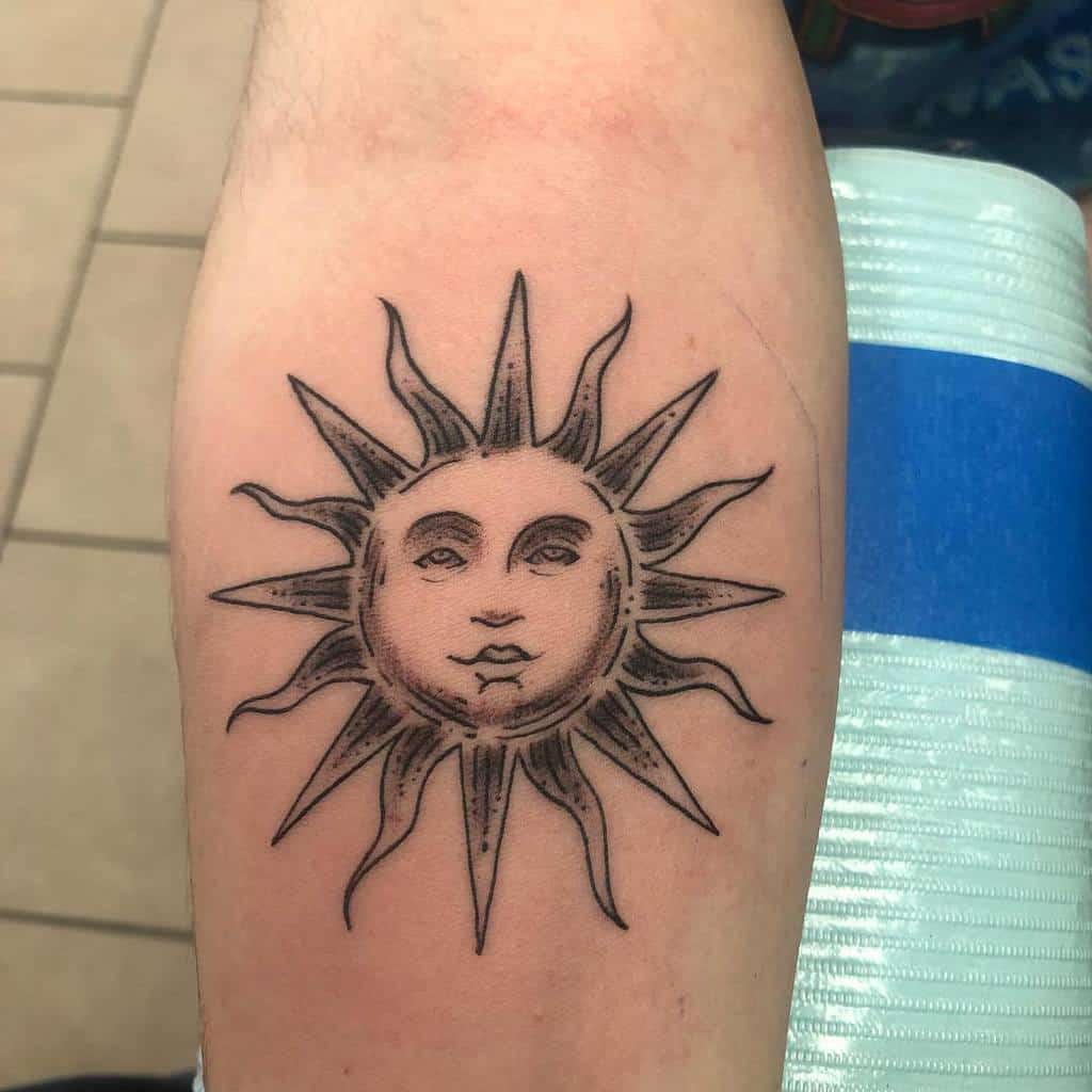 Tattoo of a sun with a human face on an arm