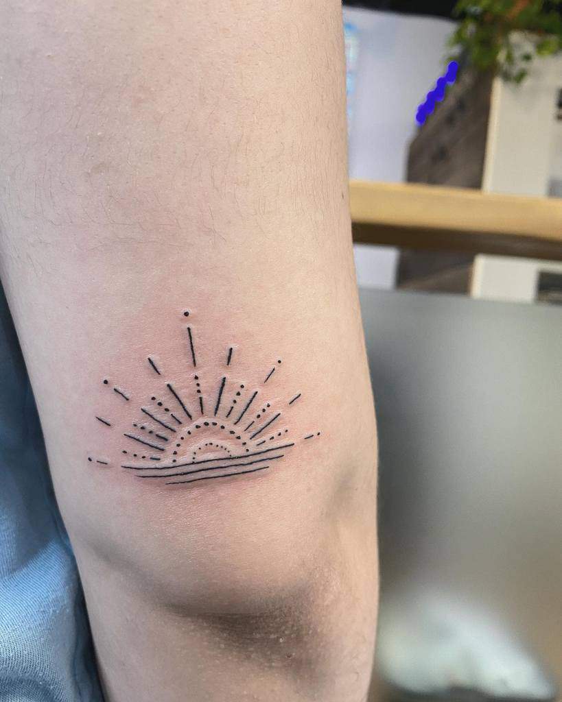 Minimalist tattoo of a sun rising over the horizon on the back of an arm