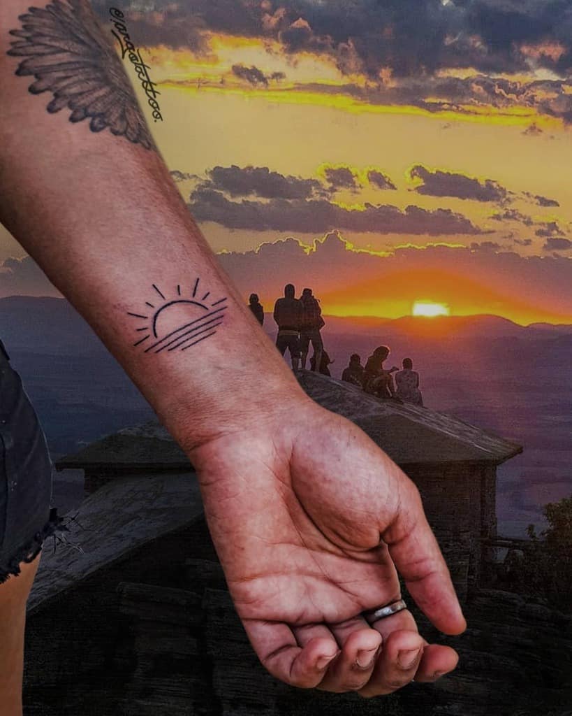 Minimalist sunset tattoo with rays and horizon lines, placed on the wrist, capturing the essence of a setting sun