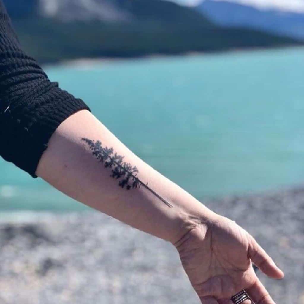 Minimalist tree silhouette tattoo on the outer forearm, symbolizing simplicity, nature, and personal connection to the outdoors