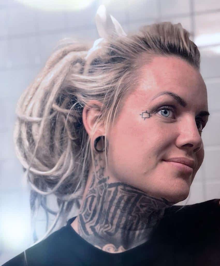 Woman with a small geometric tattoo near her eye