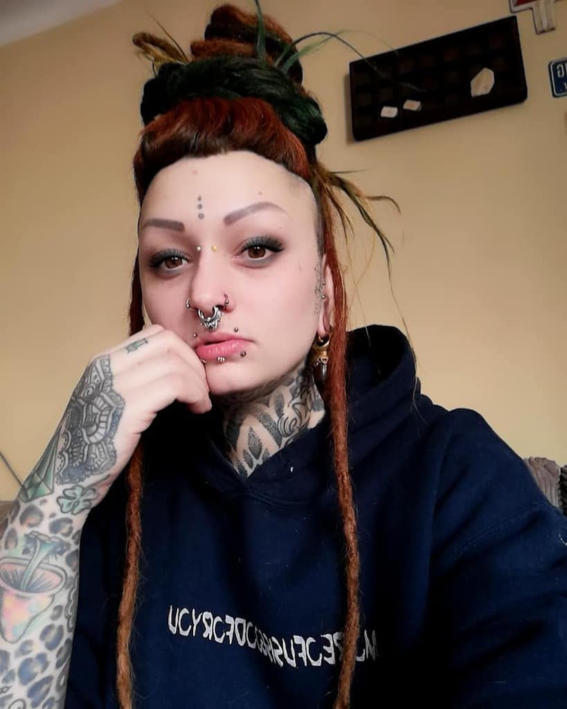 Three dots tattoo on woman's forehead