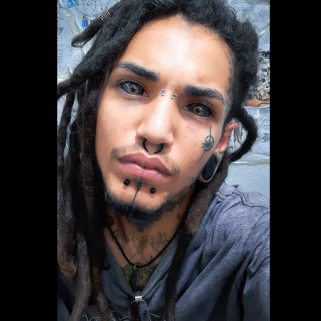 Man with a spider web tattoo on his cheek