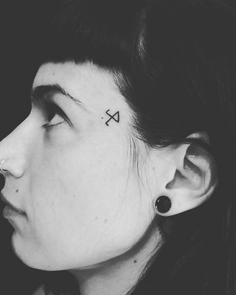 Small geometric tattoo near the temple