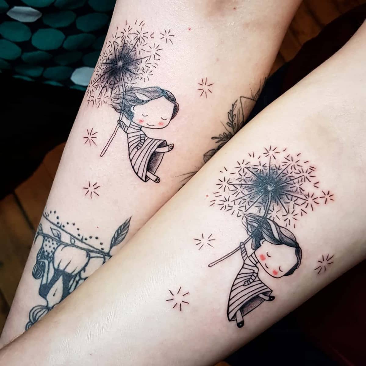 Matching tattoos of a child holding a dandelion, with delicate surrounding details