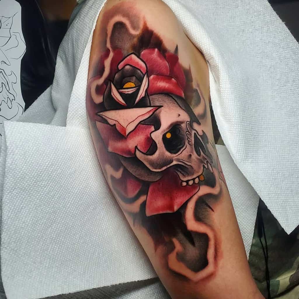 A colorful tattoo of a skull and rose on a woman's arm