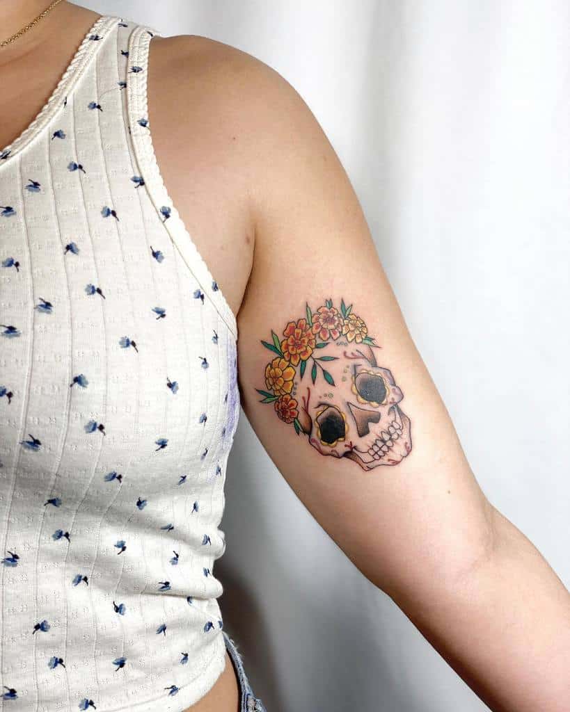Arm tattoo of a sugar skull with flowers