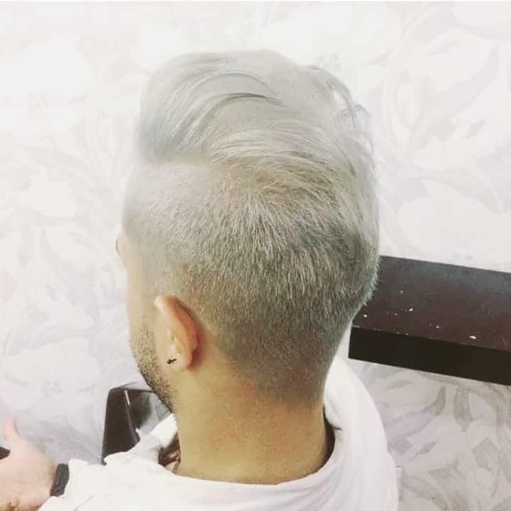 Slicked back hairstyle featuring bright platinum shade
