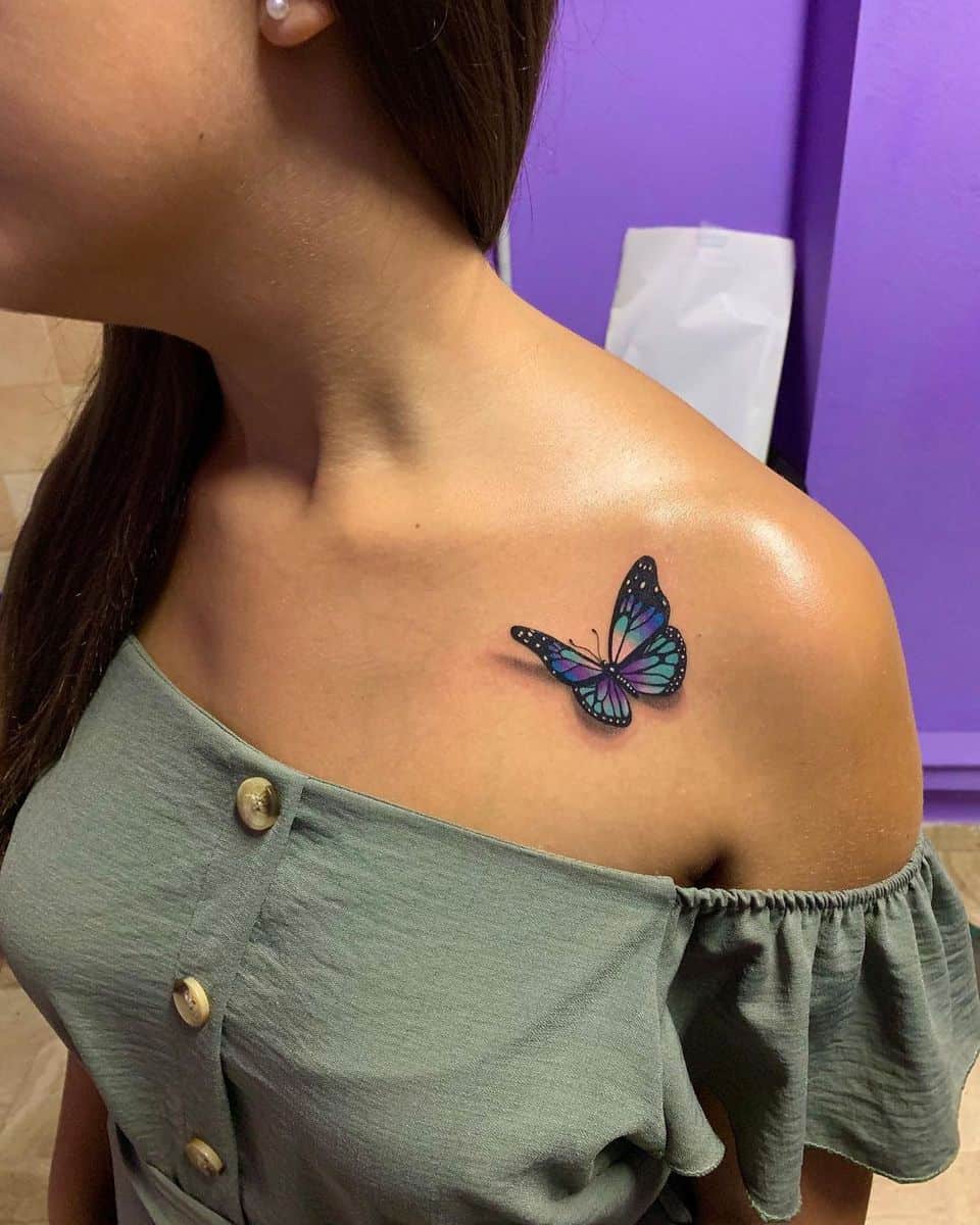 A woman with a colorful butterfly tattoo on her shoulder