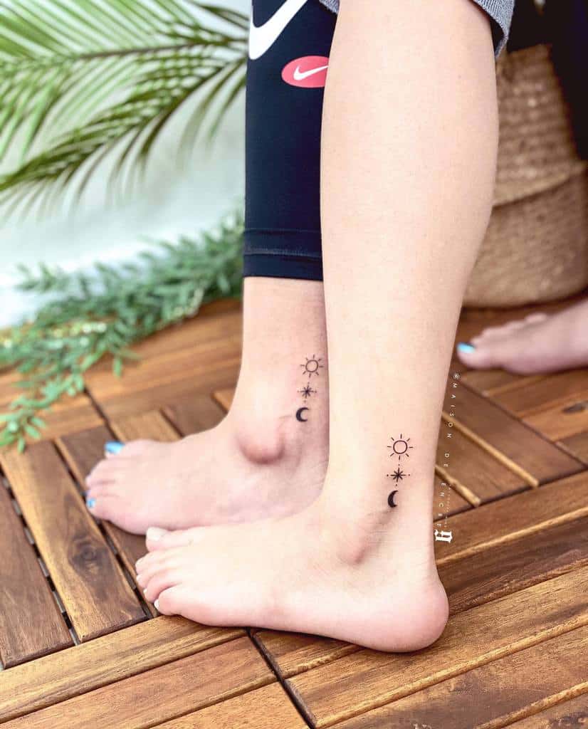 Two ankles with matching sun, moon, and star tattoos
