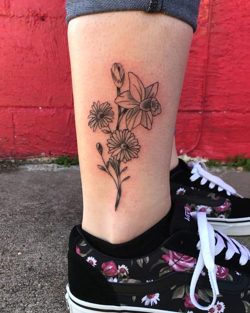 Leg tattoo of outlined asters and buds
