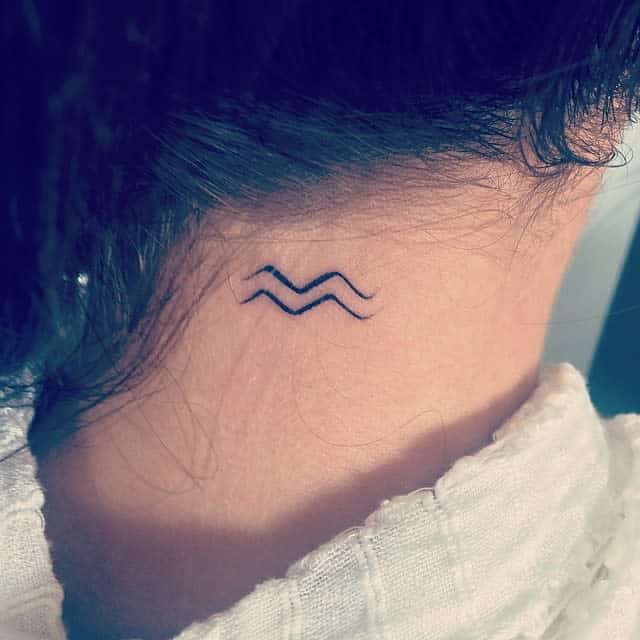 Simple wave tattoo on the back of neck under dark hair