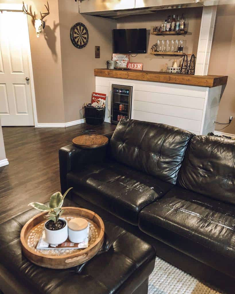 Small basement bar with dark wood countertop, wall-mounted shelves, and a mini fridge.